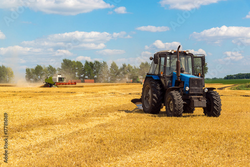 Agricultural machinery removes grain crops on field in Russia