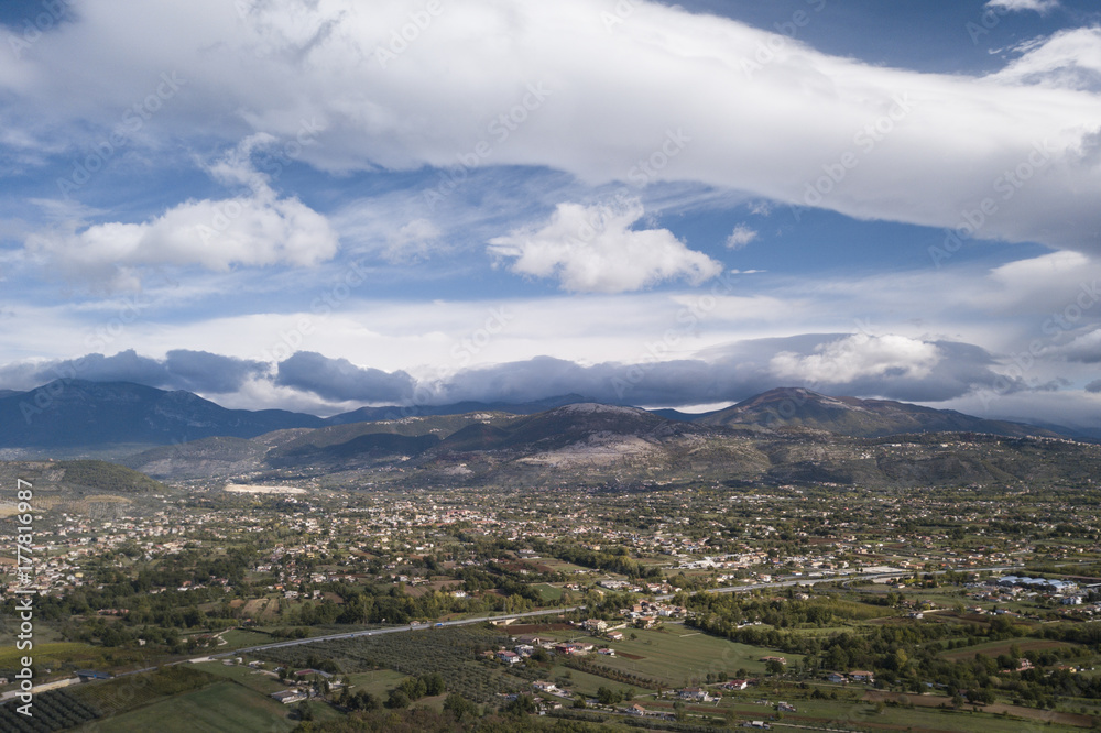 Aerial view of an Italian countryside with a dramatic and cloudy sky.