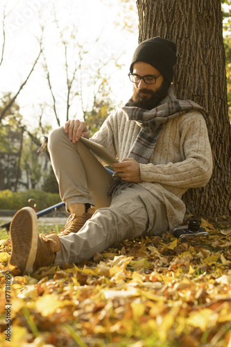 Man with beard using tablet outdoor