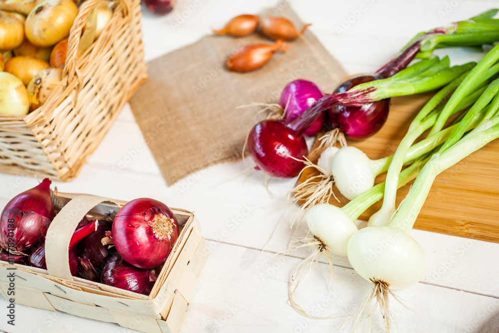 various fresh onions on a wooden table. wallpaper for grocery shopping and cooking food concept various fresh onions on a wooden table. wallpaper for grocery shopping and cooking food concept
