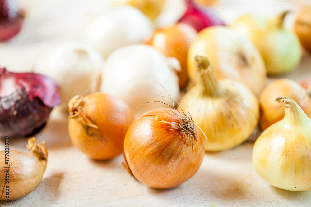 various fresh onions on a wooden table. wallpaper for grocery shopping and cooking food concept various fresh onions on a wooden table. wallpaper for grocery shopping and cooking food concept