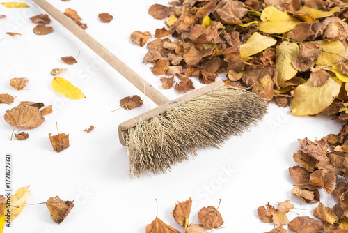 Autumnal leaves and broom isolated on white background