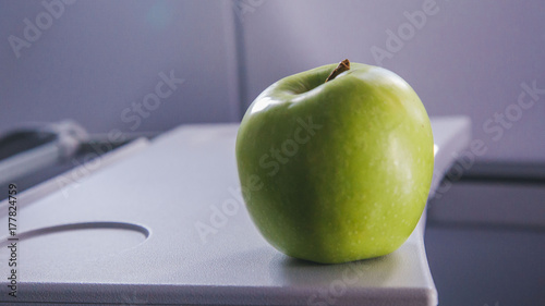 a green apple on the table of airplane photo