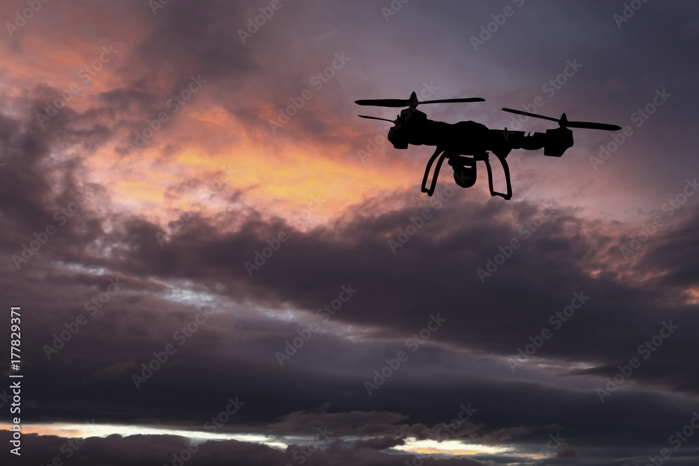 Innovation concept. Silhouette of drone flying on sunset. Heavy lift drone photographing Innovation concept. Silhouette of drone flying on sunset. Heavy lift drone photographing