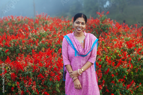 Woman in churidaar smiling in a garden photo