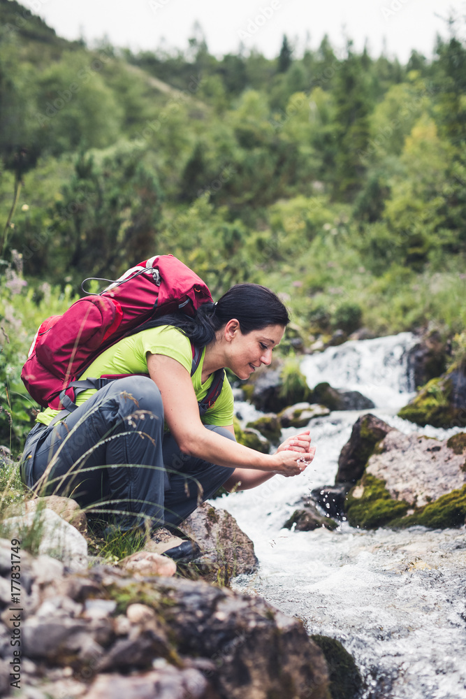 hiker drinking water from a forest brook hiker drinking water from a forest brook