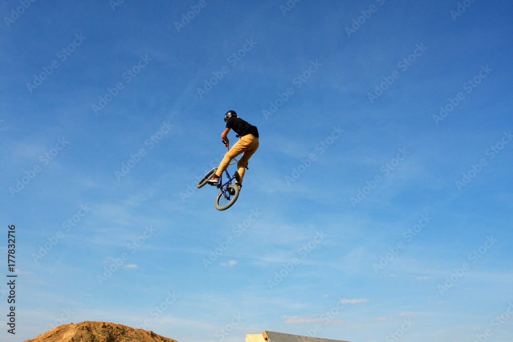 man in sportswear jumping high on mountain bicycle on background of landscape. man in sportswear jumping high on mountain bicycle on background of landscape.