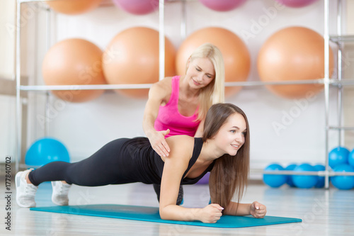 Young woman exercising with her fitness instructor