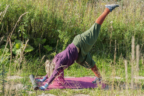  Young woman practicing yoga, warm up routine based on a sequence of gracefully linked asanas