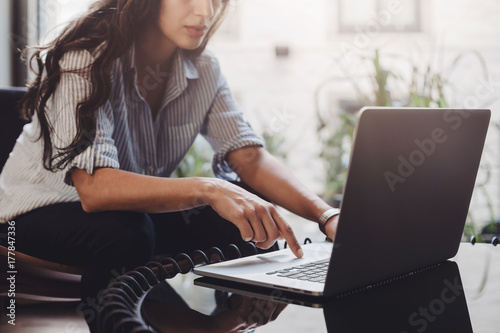 Business woman working on laptop in loft interior