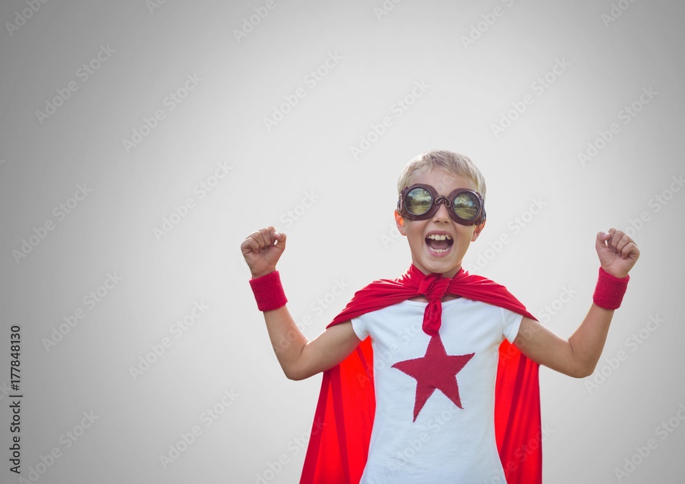 Boy against grey background with superhero costume Boy against grey background with superhero costume