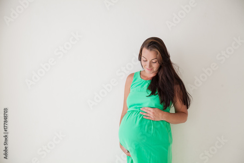 a pregnant woman is standing at the wall next to the window