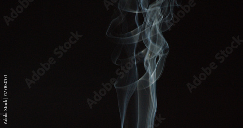 Thin tall trail of smoke on dark background