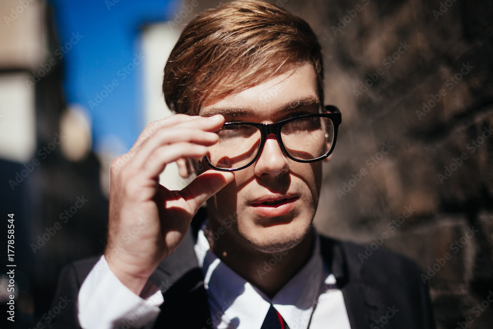 Young Elegant Businessman Putting On Reading Glasses Young Elegant Businessman Putting On Reading Glasses