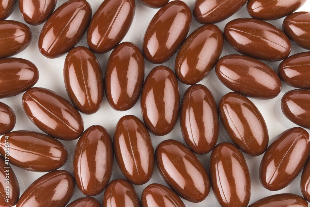 Fototapeta premium vitamin E. supplementary food. color brown capsule. isolated on white background