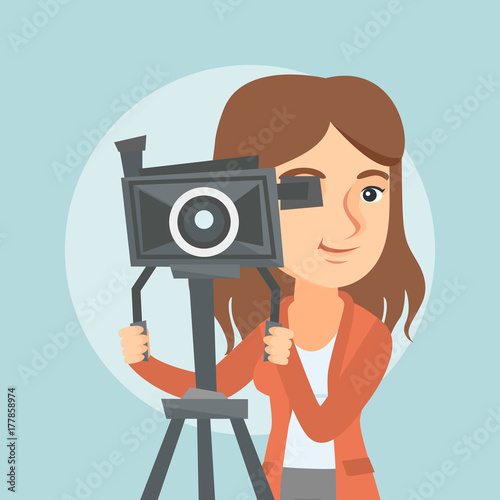 Caucasian cameraman looking through a movie camera on a tripod. Young cameraman with a professional video camera. Female cameraman taking a video. Vector cartoon illustration. Square layout.