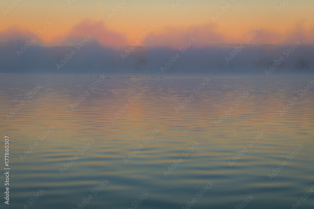 Obraz premium Fog creates a muted palette at dawn on Silver Lake, Castile, NY, in early fall