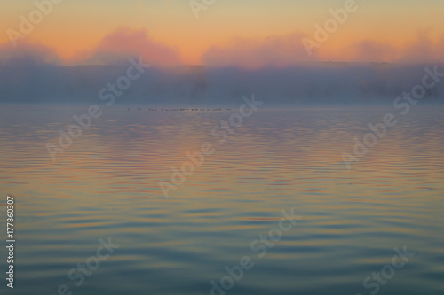 Fog creates a muted palette at dawn on Silver Lake  Castile  NY  in early fall