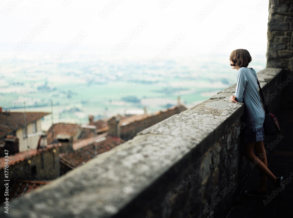Girl looking out on a view from Cortona, Italy. Girl looking out on a view from Cortona, Italy.