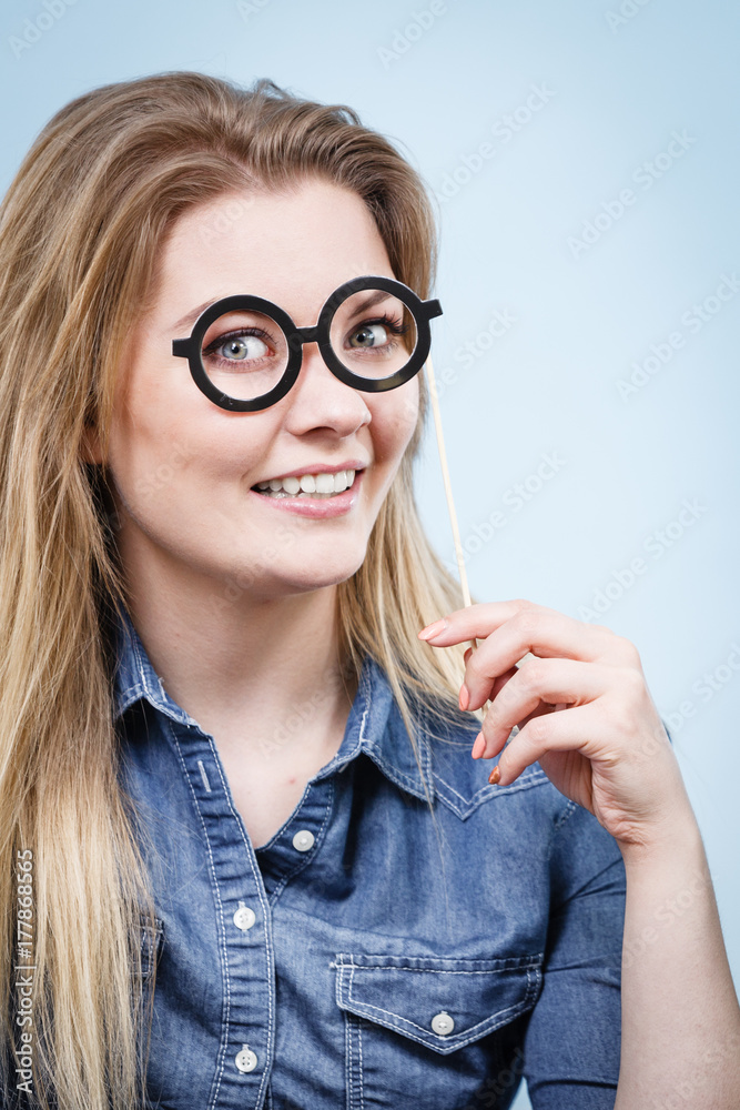 Happy woman holding fake eyeglasses on stick Happy woman holding fake eyeglasses on stick