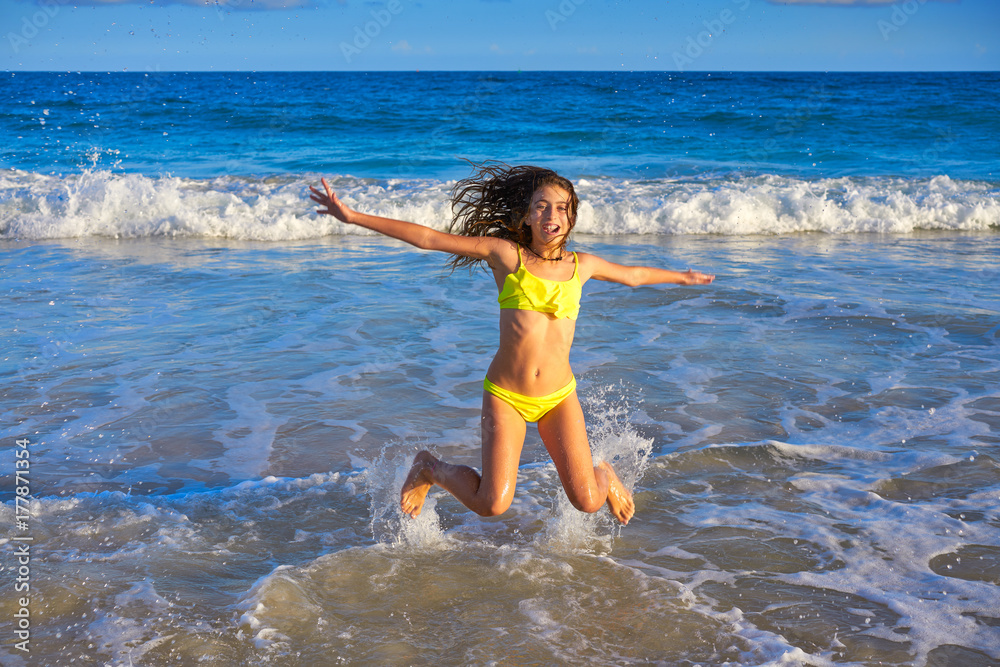 Fototapeta premium Bikini girl jumping in Caribbean sunset beach