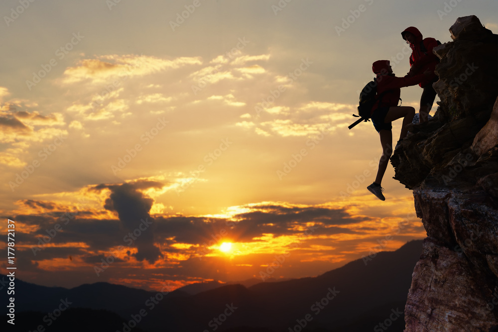 Teamwork hiking help each other trust assistance at mountains and beautiful sunrise,teamwork and hiking concept.