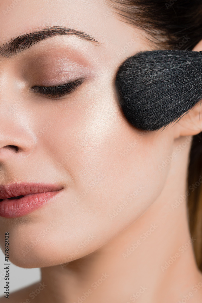 Beautiful woman with makeup brushes near her face Beautiful woman with makeup brushes near her face