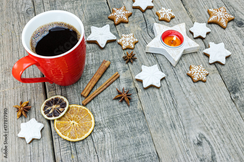 gingerbread star cookies with spiced fruit and cup of coffee on grey weathered background