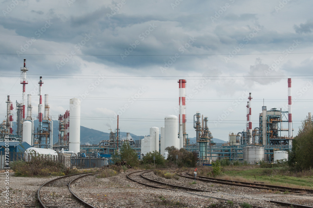 panorama usine chimique et voie de chemin de fer sur fond de ciel nuageux