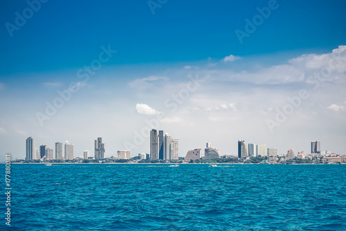 Speed boats and city buildings near the sea  sky and clouds