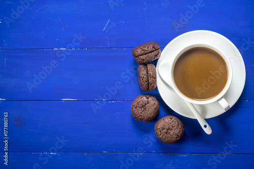 coffee and cookie on blue wooden background with flat lay image