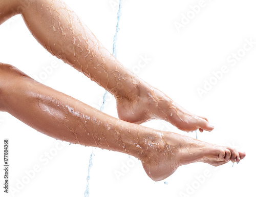 Sensual woman's legs in clean water splashes.