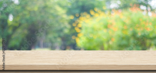 Empty wooden table over blurred tree park nature with bokeh background, for product display montage, banner