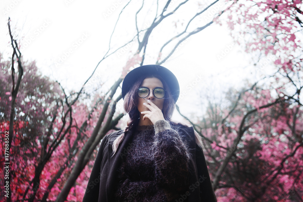 A girl smokes on a background the forest A girl smokes on a background the forest