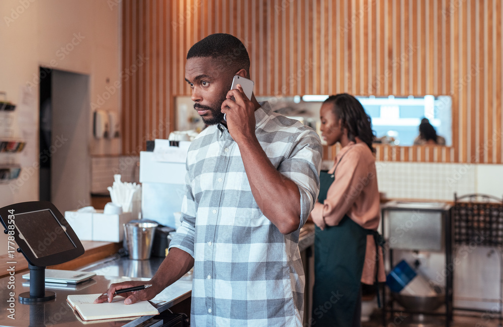 Young African entrepreneurs busy working behind their cafe counter