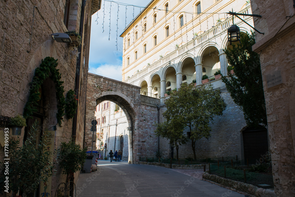 Archway between elegant architecture in the streets of Assisi, Umbria, Italy