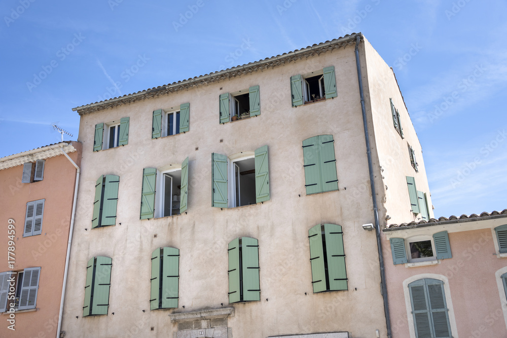 Fototapeta premium France, Provence, French Riviera, Draguignan, Lorgues: Old french house facade with open closed traditional wooden shutters painted with pastel color.