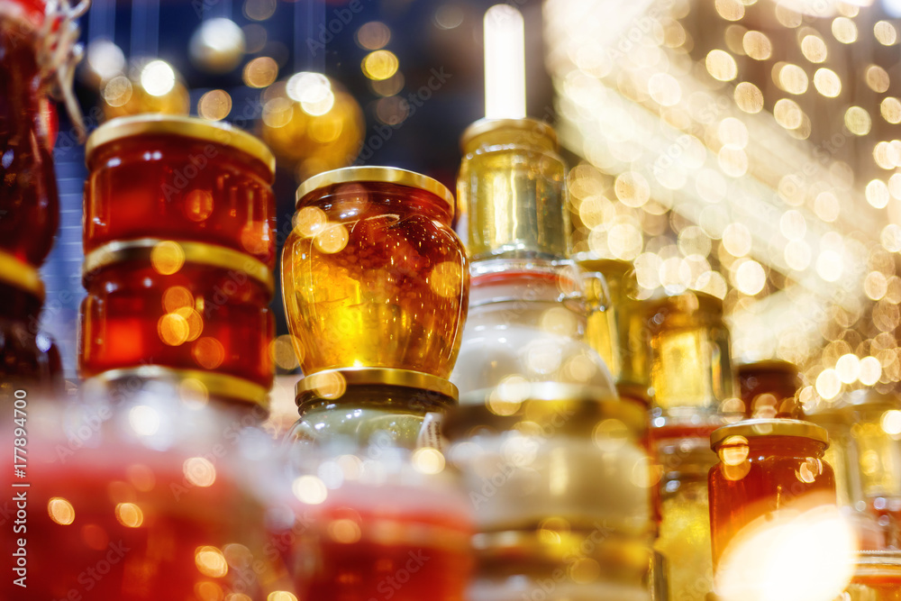 Holiday fair. Jars of honey glowing in garlands of lighting bulbs. Holiday fair. Jars of honey glowing in garlands of lighting bulbs.