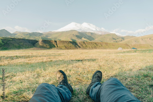 Man sitting in front of mountain Elbrus.