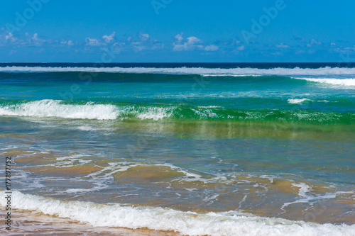 Sunlit ocean waves and blue sky