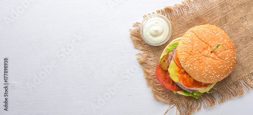 Burger and potatoes with sauce. On a wooden background. Top view. Free space for your text.
