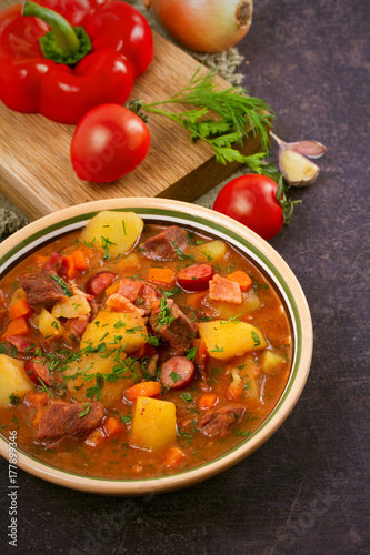 Tasty stew. Goulash soup bograch in a bowl and ingredients. Hungarian dish, vertical