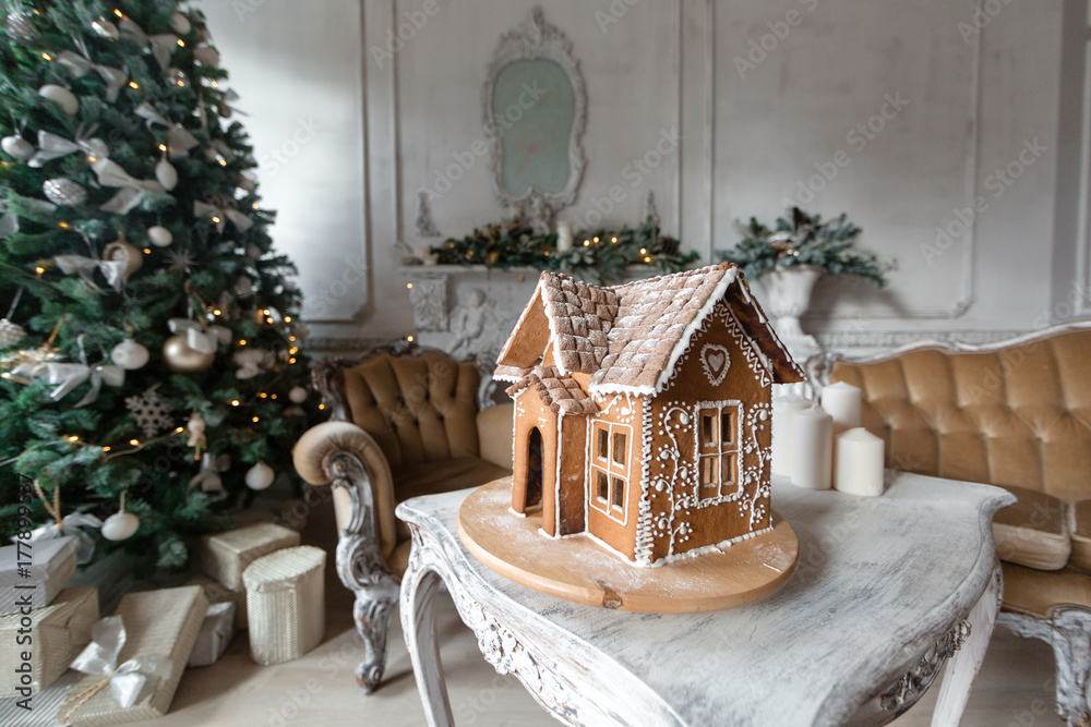 Homemade gingerbread house on background room decorated for Christmas