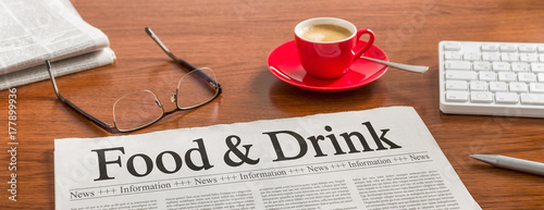 A newspaper on a wooden desk - Food and Drink