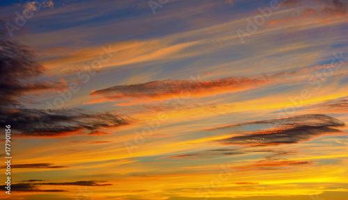 Photo of orange sunset with dark clouds on sky © Badunchik