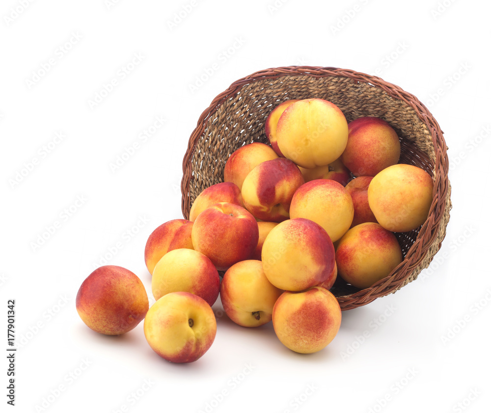 Apricots in a basket of straw on a white background