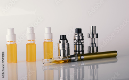 isolated vape tanks and e liquid for electronic cigarette or e cig over a white background. vaping rdta and e juice for vaping devices.