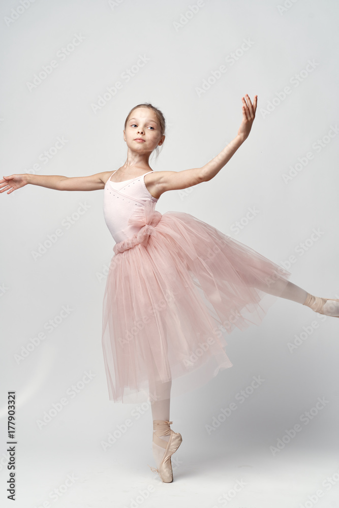 A small ballerina in a light dress demonstrates her skills A small ballerina in a light dress demonstrates her skills