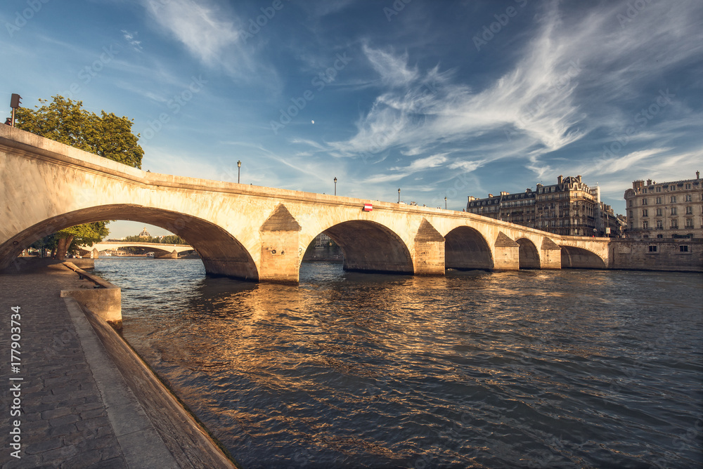 Bridge over river Seine in Paris, France at daytime viewed from a quay. Travel and architectural background. Romantic cityscape.