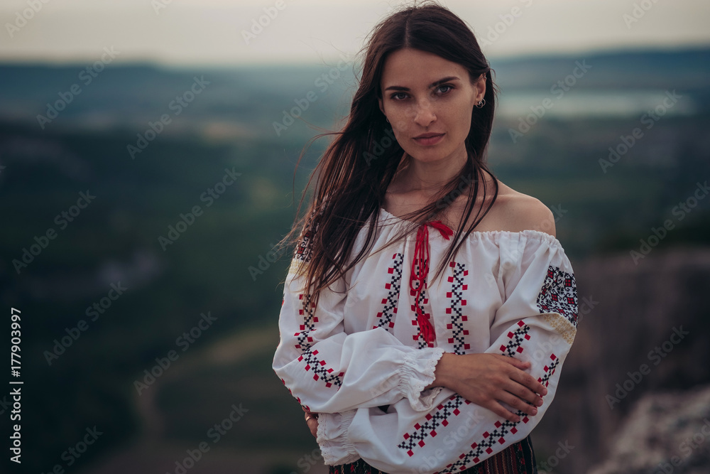 Atractive Woman In Traditional Romanian Costume On Mountain Green Blurred Background Outdoor